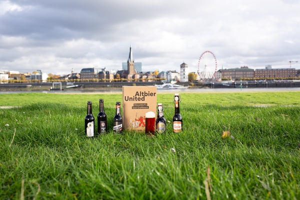 altbier united altbier geschenkpaket auf wiese vor düsseldorfer altstadt